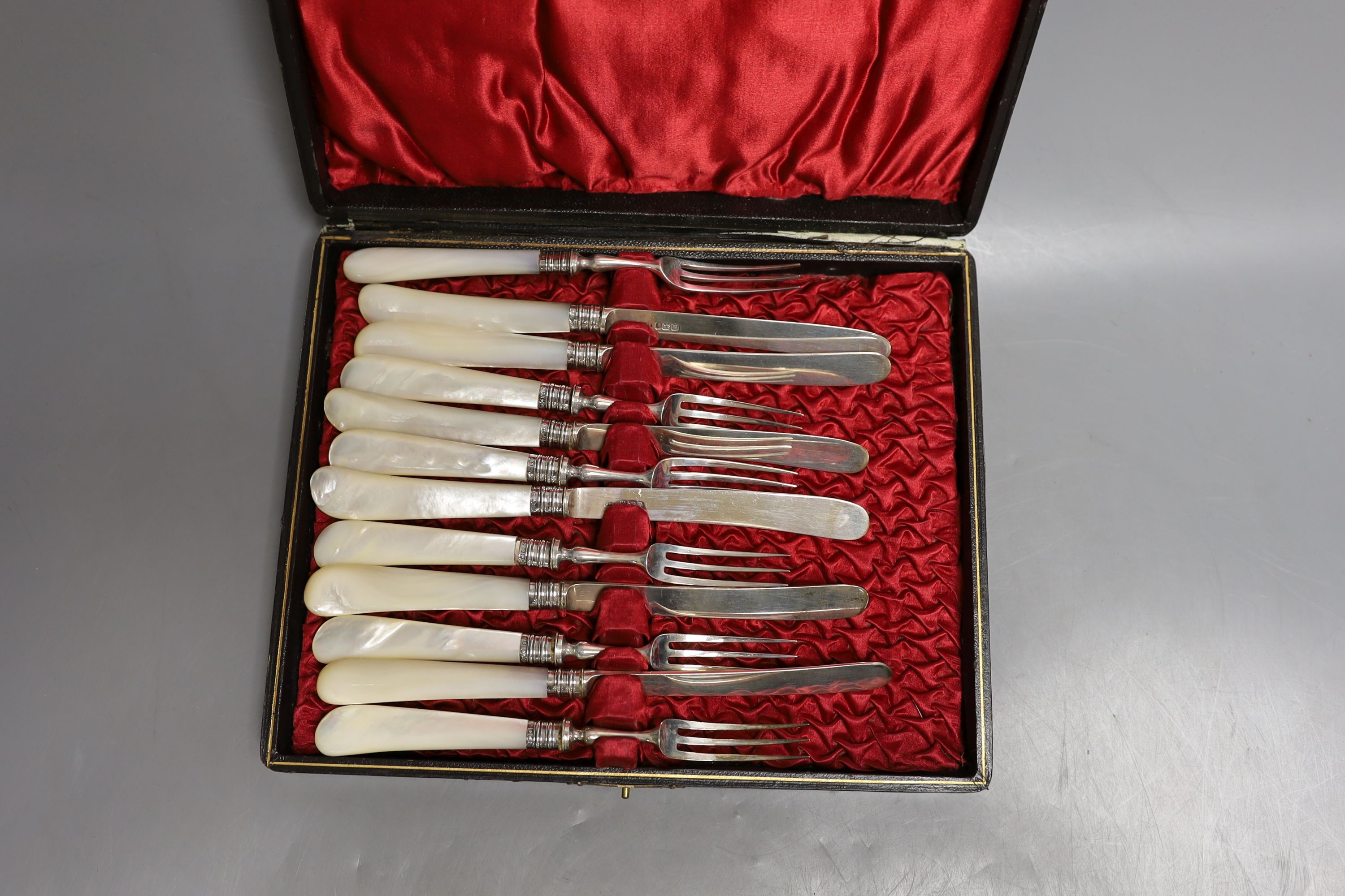 A cased set of six pairs of Edwardian mother of pearl handled silver dessert eaters, Sheffield, 1902.